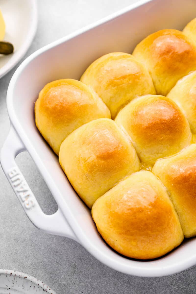 close up of dinner rolls in a white baking dish.