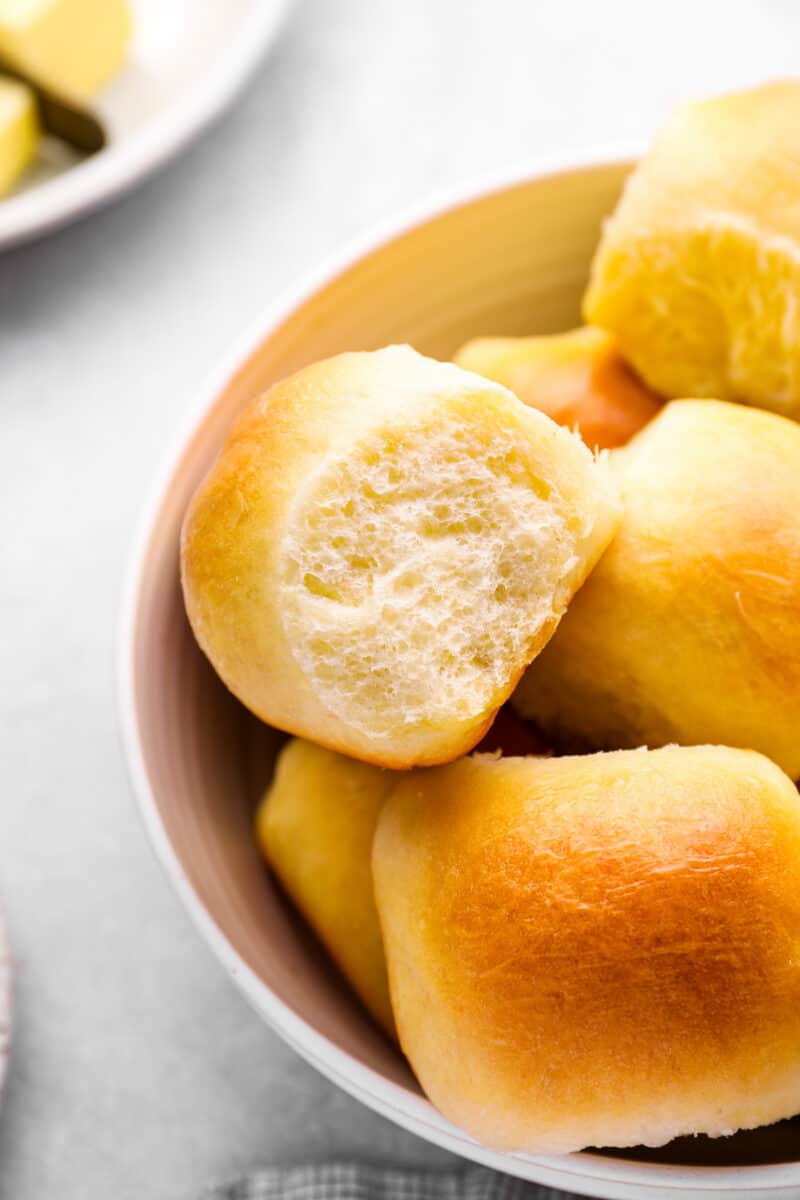 close up of dinner rolls in a white bowl.