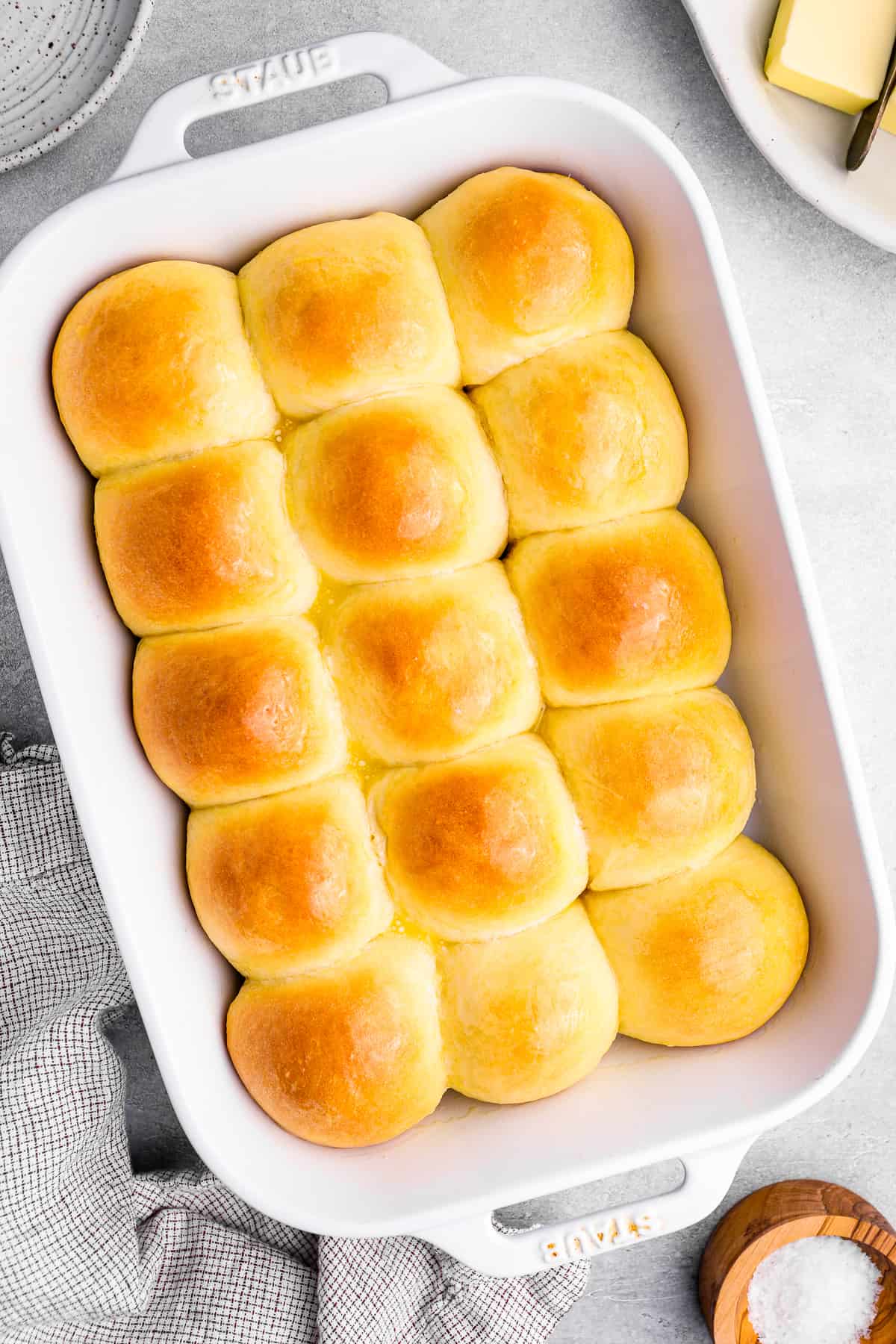 overhead view of 15 dinner rolls in a white baking dish.