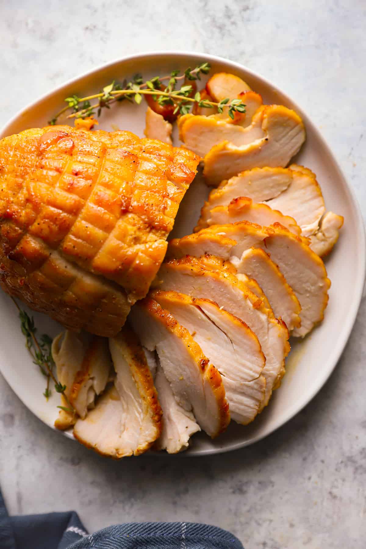 sliced honey baked turkey breast on a white serving platter.