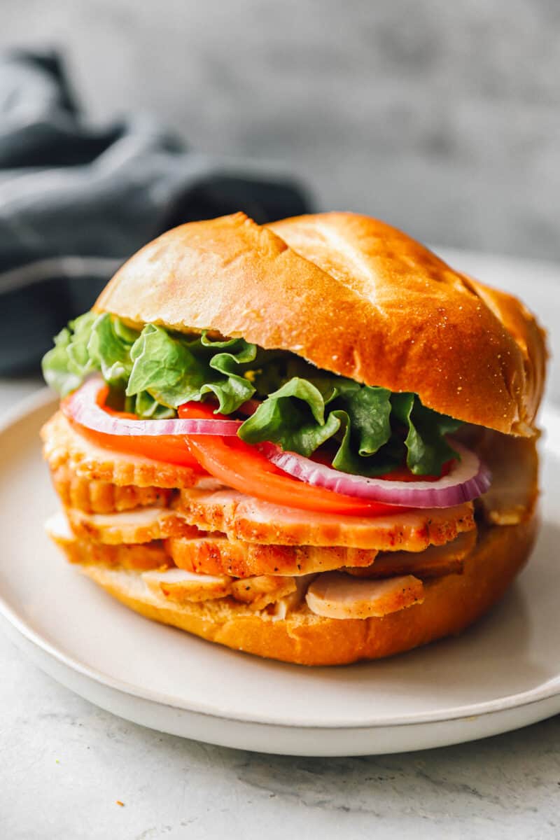 a honey baked turkey sandwich with tomato, onion, and lettuce.