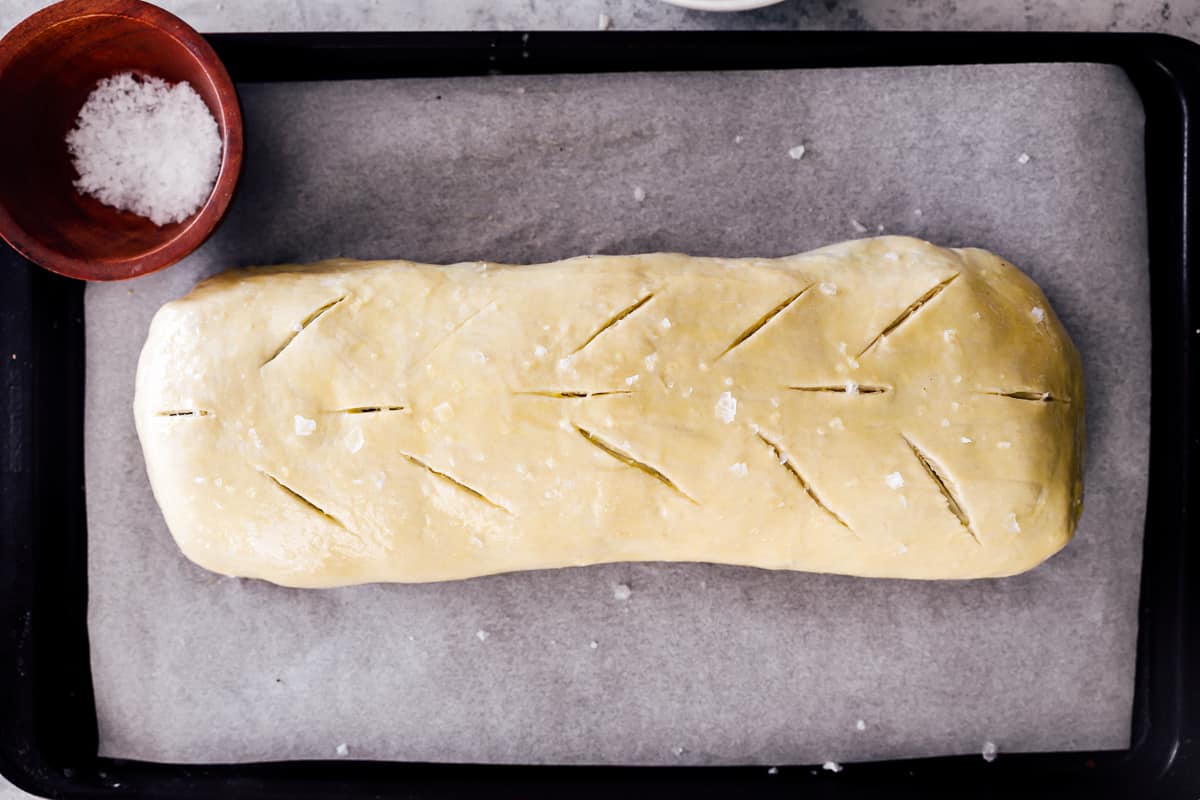 scored beef wellington on a baking sheet.