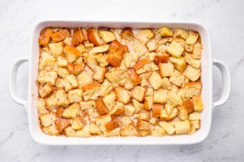 unbaked bread pudding in a white baking dish.