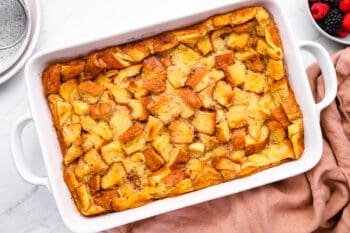 baked bread pudding in a white baking pan.