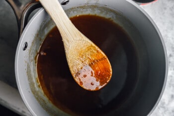 brown sugar glaze in a saucepan with a wooden spoon.