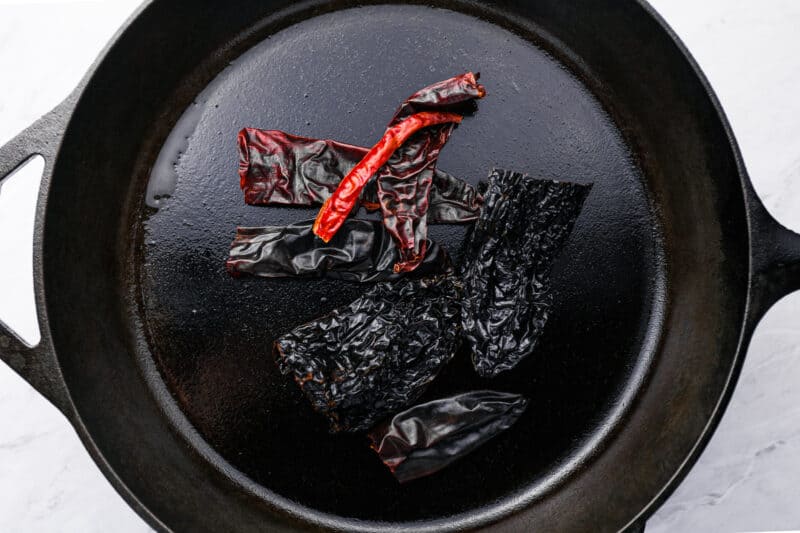 dried chilis in a cast iron pan.