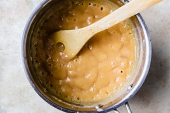 sugar and evaporated milk mixture in a saucepan with a wooden spoon.