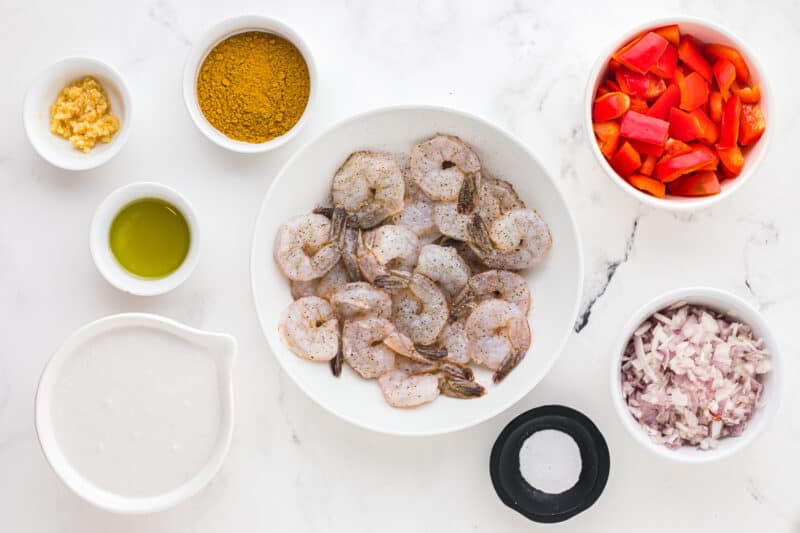 overhead view of ingredients for coconut curry shrimp in individual bowls.