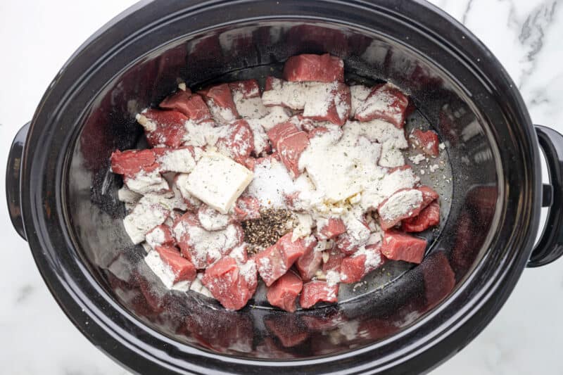 ranch seasoning, salt, and pepper on top of cubed sirloin in a crockpot.