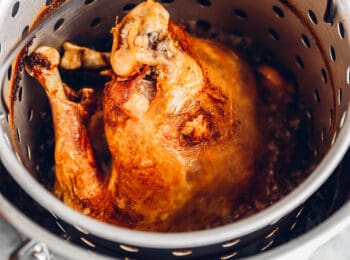 close up of deep fried turkey in a strainer basket.