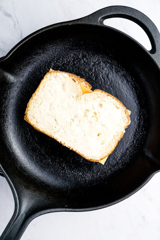 a grilled cheese sandwich in a cast iron pan.