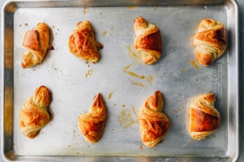 8 baked croissants on a baking sheet.