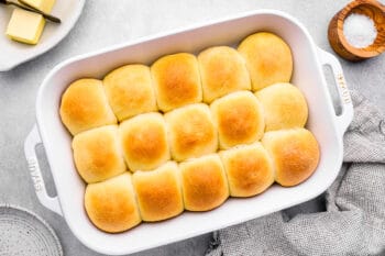15 dinner rolls in a white baking pan.