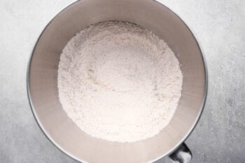 dry ingredients for dinner rolls in a stainless mixing bowl.