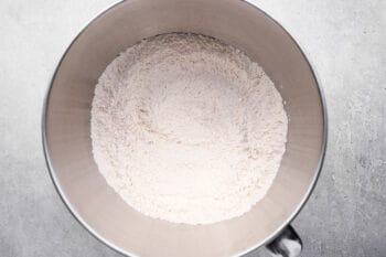 dry ingredients for dinner rolls in a stainless mixing bowl.