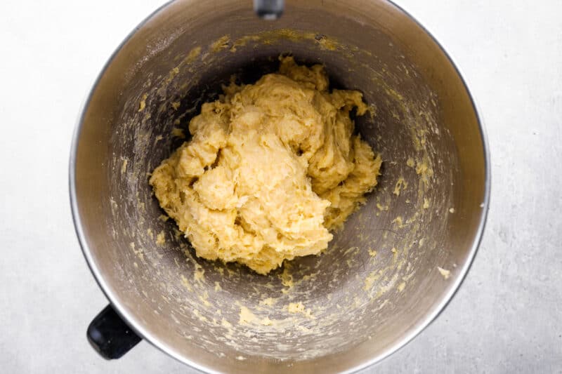 mixed dinner roll dough in a stainless mixing bowl.