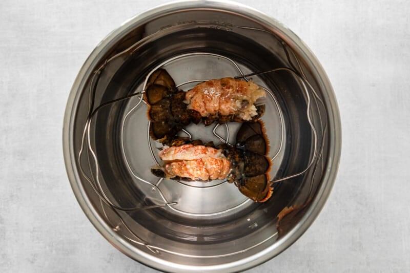 two prepared lobster tails in an instant pot.