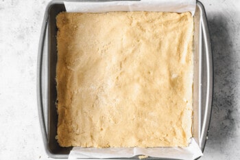 shortbread dough pressed into a square baking pan.