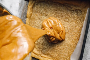 caramel poured over baked shortbread in a square baking pan.