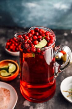 jingle juice in a pitcher surrounded by garnishes.