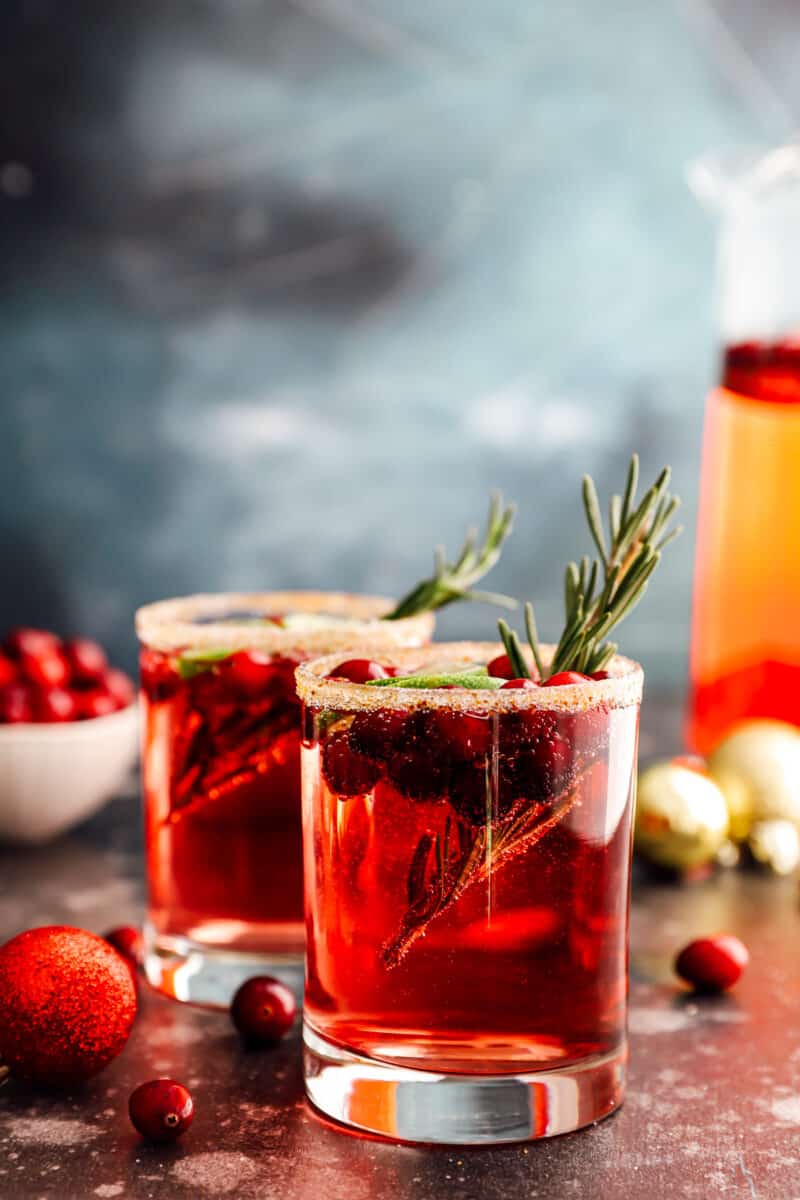 2 glasses of jingle juice garnished with rosemary sprigs.