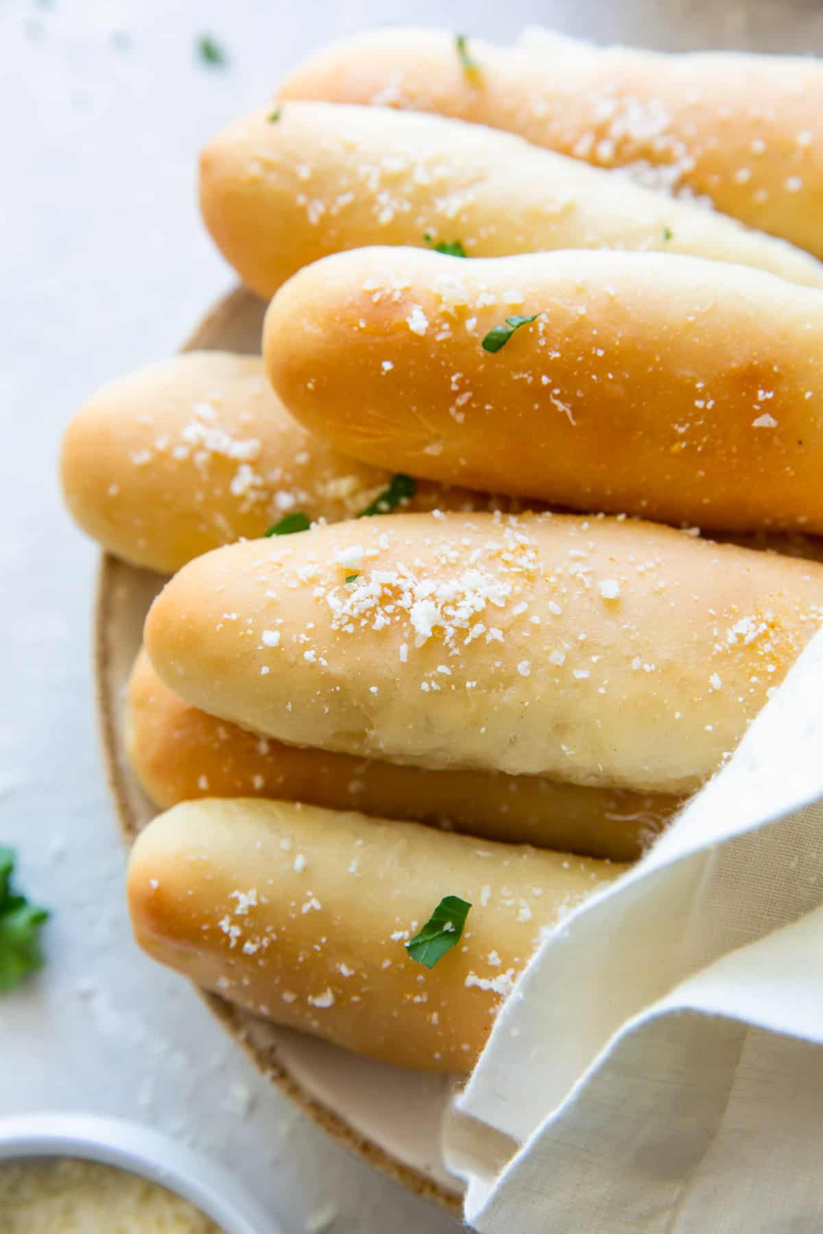 olive garden breadsticks on a white plate with a towel draped over them.