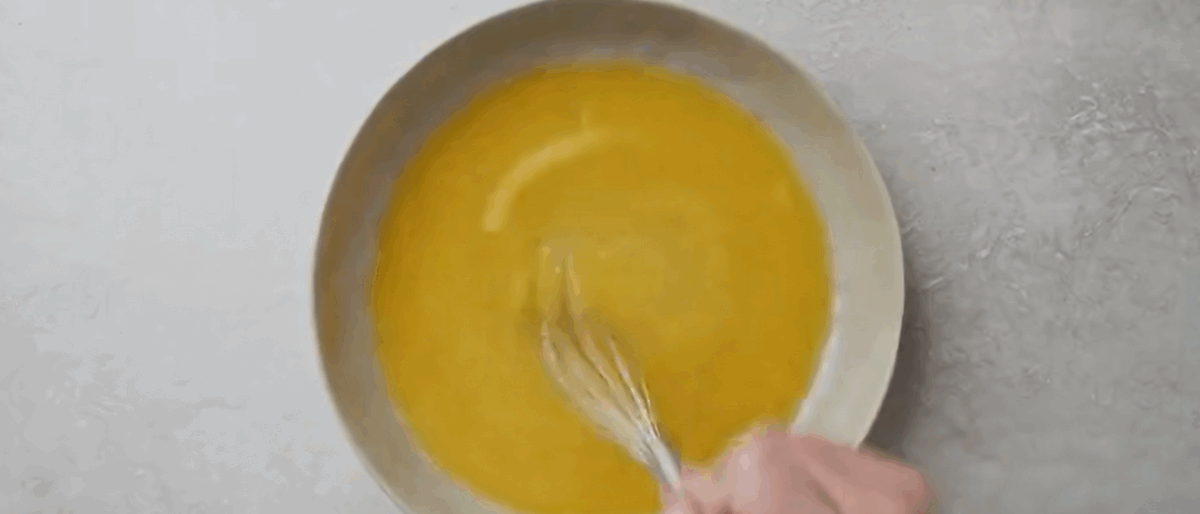 Preparing the butter mixture in a white bowl.
