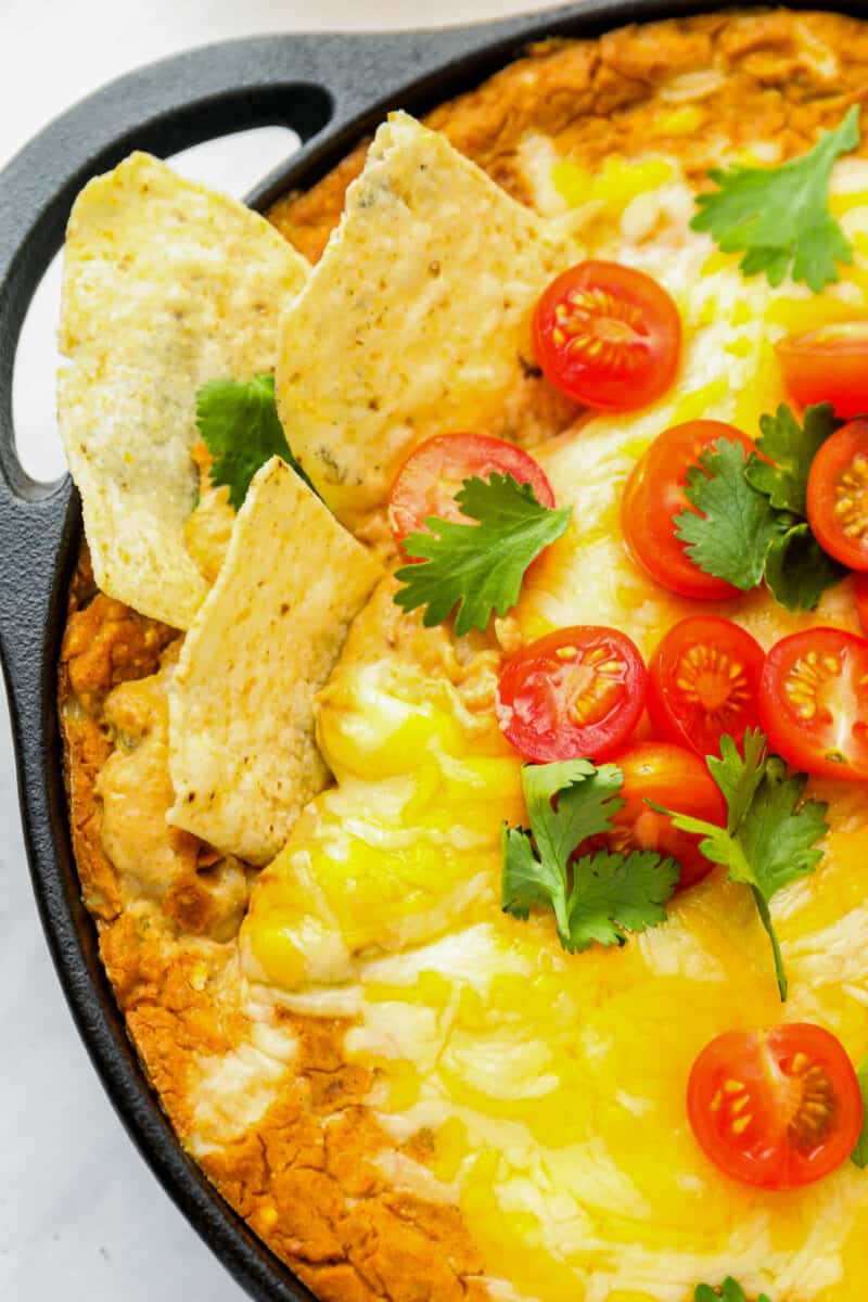 partial view of cheesy bean dip in a cast iron skillet.