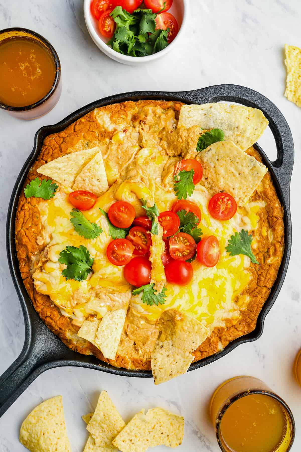 overhead view of cheesy bean dip in a cast iron skillet with the handle pointing to the left.