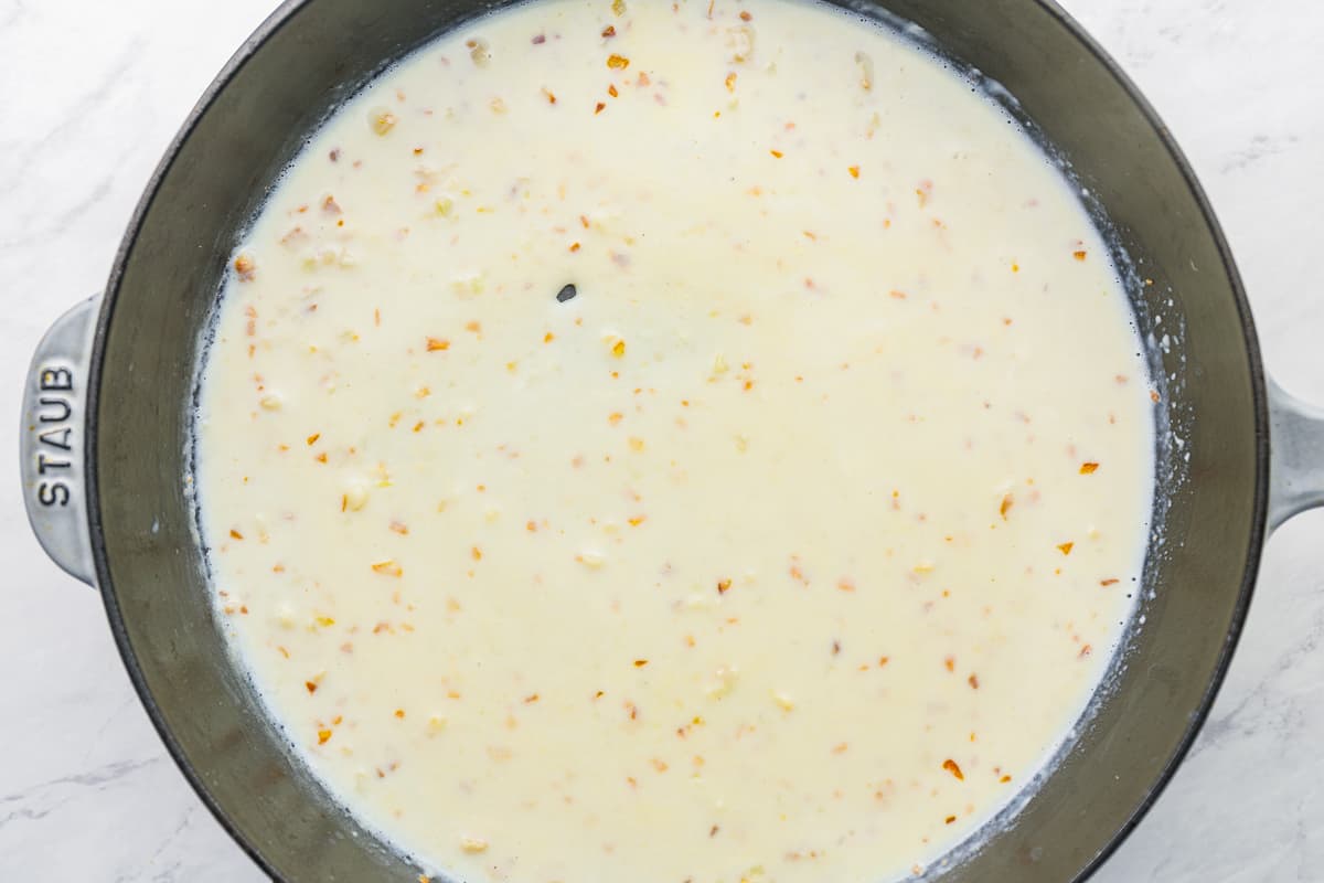 Flour and milk added to garlic and butter in a cast iron pan.