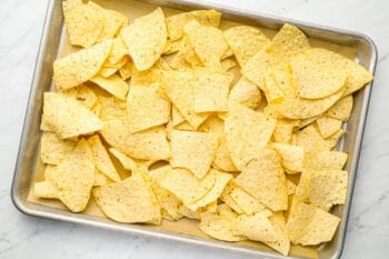 tortilla chips spread over a baking sheet.