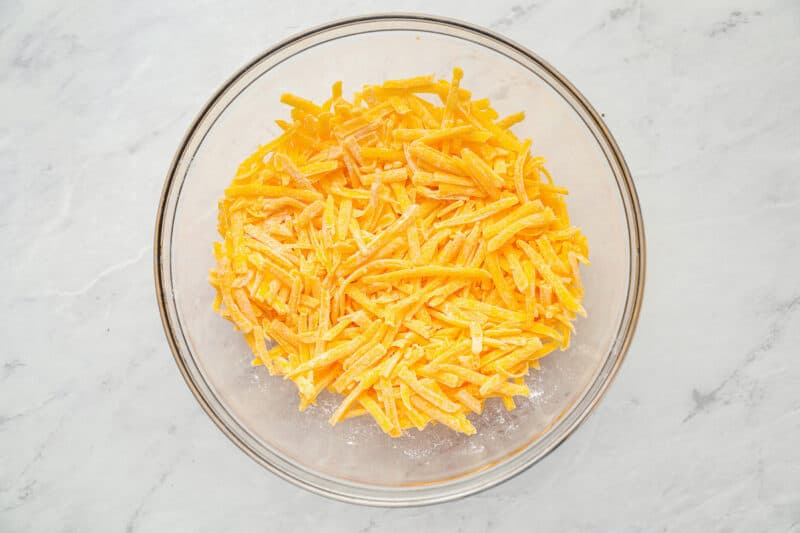 shredded cheese and cornstarch in a glass bowl.