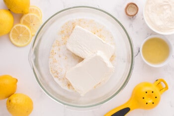 cream cheese added to lemon sugar in a glass bowl.