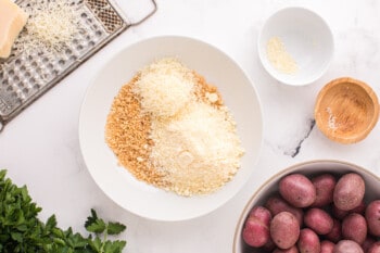 cheeses and breadcrumbs mixed together in a white bowl.