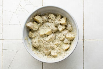 pesto potato salad in a white bowl.