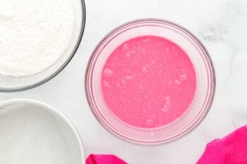 wet ingredients for pink velvet cake batter in a glass bowl.