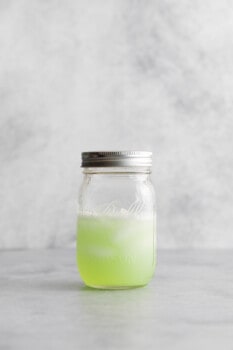 shaken poison apple martini in a sealed mason jar with ice.