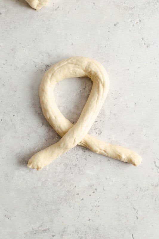 homemade pretzel dough log in a loop shape.