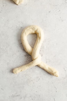 homemade pretzel dough log in a twisted loop shape.