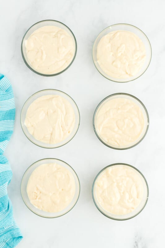 overhead view of cake batter in 6 glass bowls.