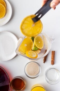 fruits added to a large glass pitcher.