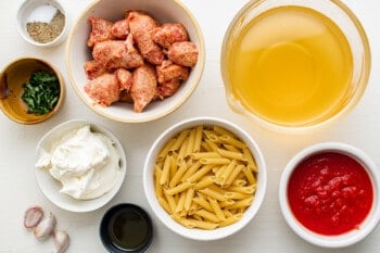 overhead view of ingredients for sausage pasta in individual bowls.