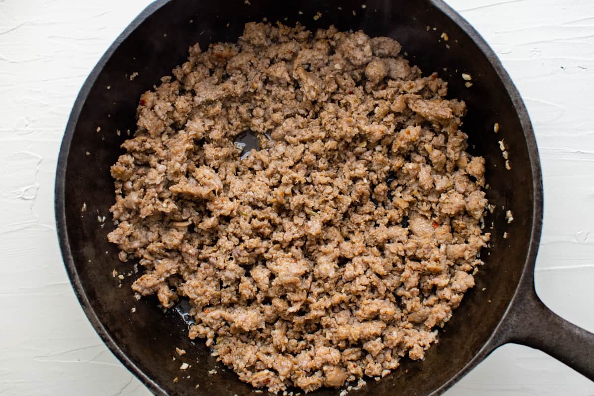 cooked crumbled sausage in a cast iron pan.