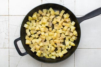 boiled cubed potatoes in a cast iron skillet.
