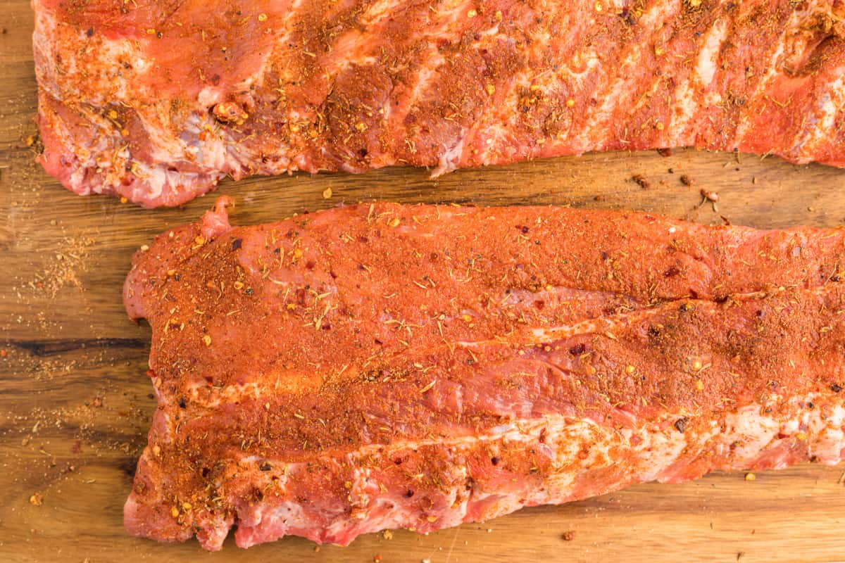 spice rubbed ribs on a wooden cutting board.