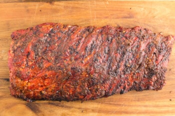 smoked ribs on a wooden cutting board.