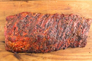 smoked ribs on a wooden cutting board.