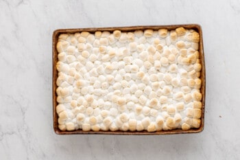 broiled marshmallows on top of smores bars in a rectangular baking pan.