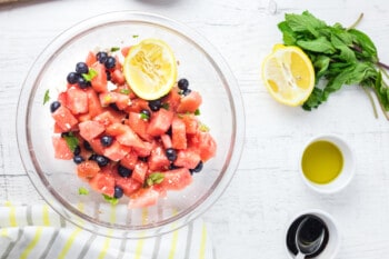 watermelon salad mixed together in a glass bowl.