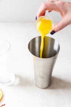 orange juice poured into a cocktail shaker.